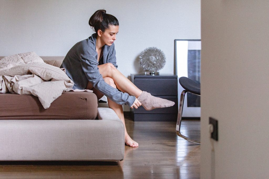 woman putting on diabetic sock