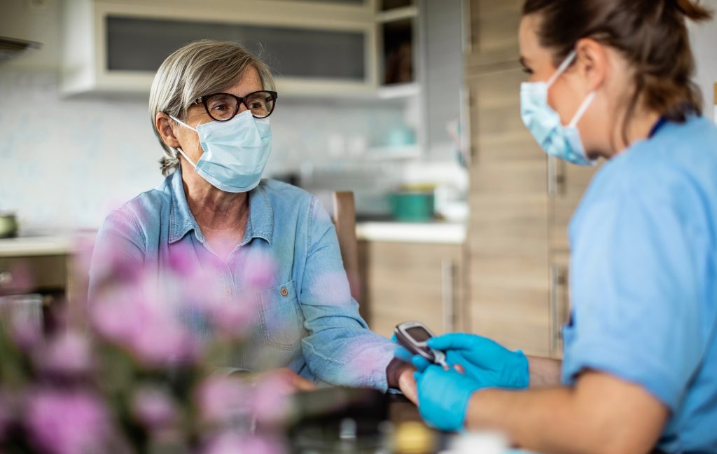 nurse checking patient's blood sugar