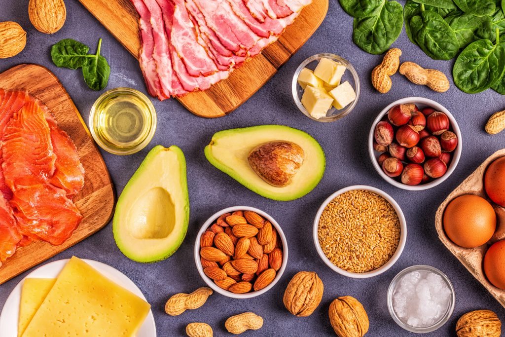 selection of keto-friendly foods: bacon, cheese, legumes, nots, avocado