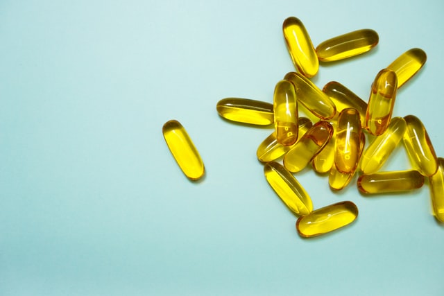 vitamin/supplement gelcaps against light blue background
