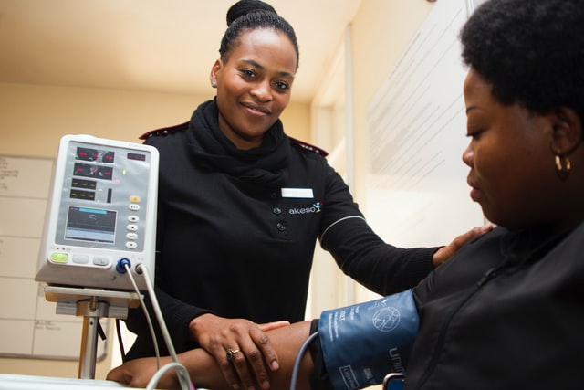 Female black healthcare professional administering blood pressure test on female black diabetic patient